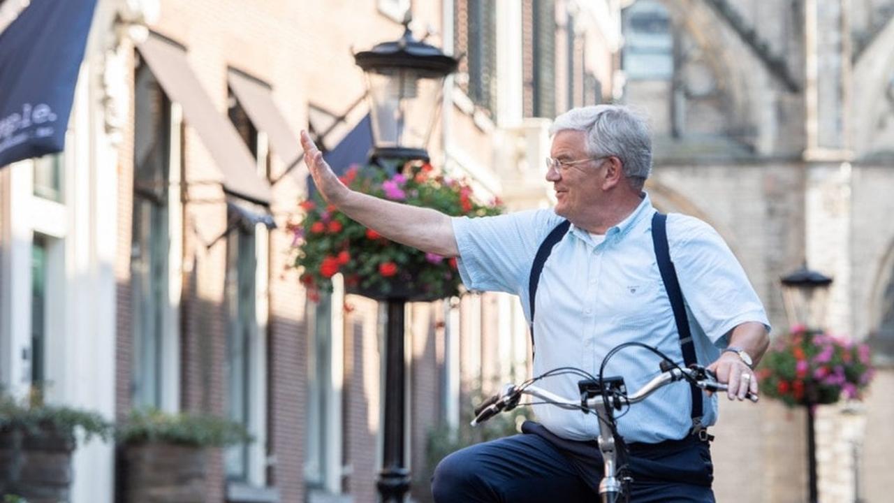 foto van oud-burgemeester Jan van Zanen op de fiets die zwaait