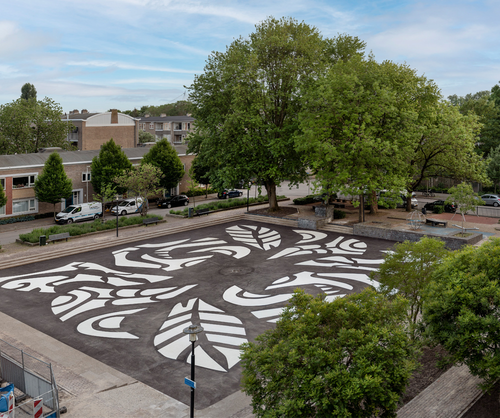 foto van het Herderplein van boven, met zwart-witte patronen van planten en dieren in het asfalt